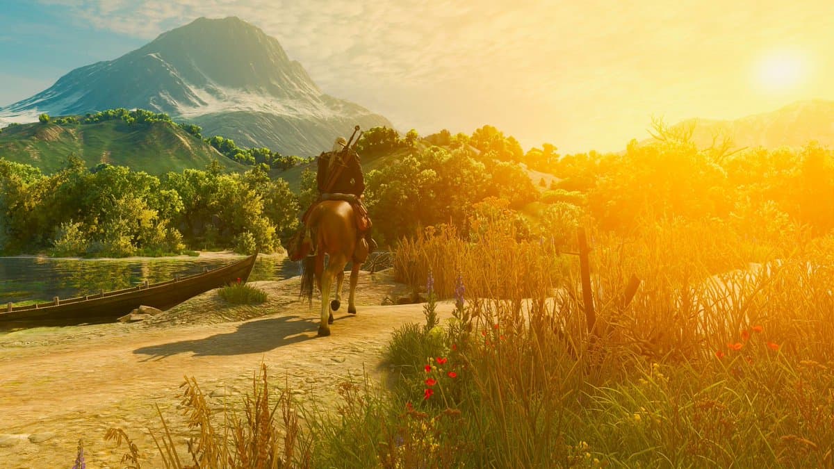 A man on his horse in a picturesque springtime countryside, with a golden sun hanging low.