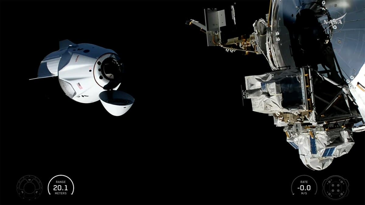 The SpaceX Dragon, with its nose cone open and carrying four Crew-13 members, approaches the International Space Station for a docking.