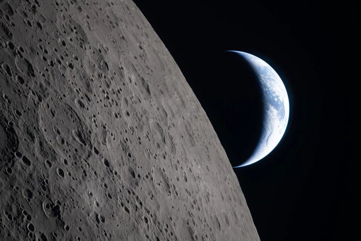 The Moon, as seen by Artemis II astronauts just before they passed behind it. The edge of the visible surface of the Moon, or the limb, is visible. Just beyond that is Earth, lit like a crescent moon.